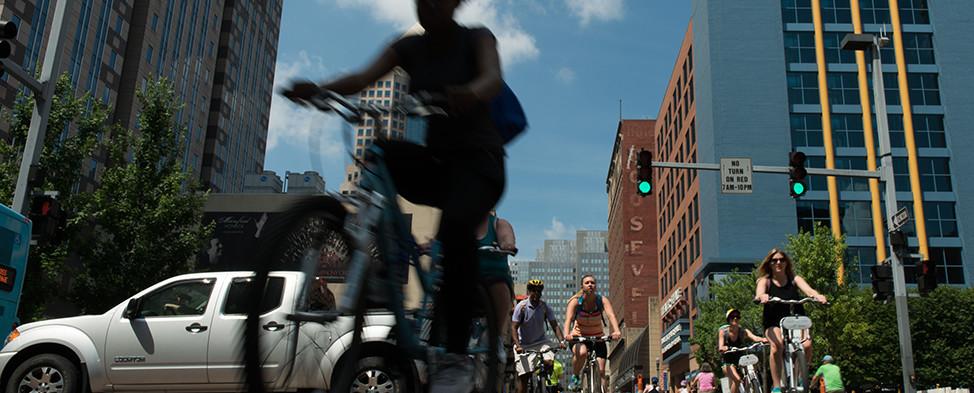 People riding bikes through Downtown Pittsburgh during 2016 OpenStreetsPGH when certain streets were closed to automobiles.